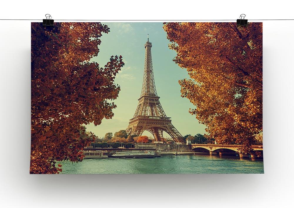 Eiffel Tower surrounded by autumn foliage, showcasing vibrant fall colors in a stunning canvas print.