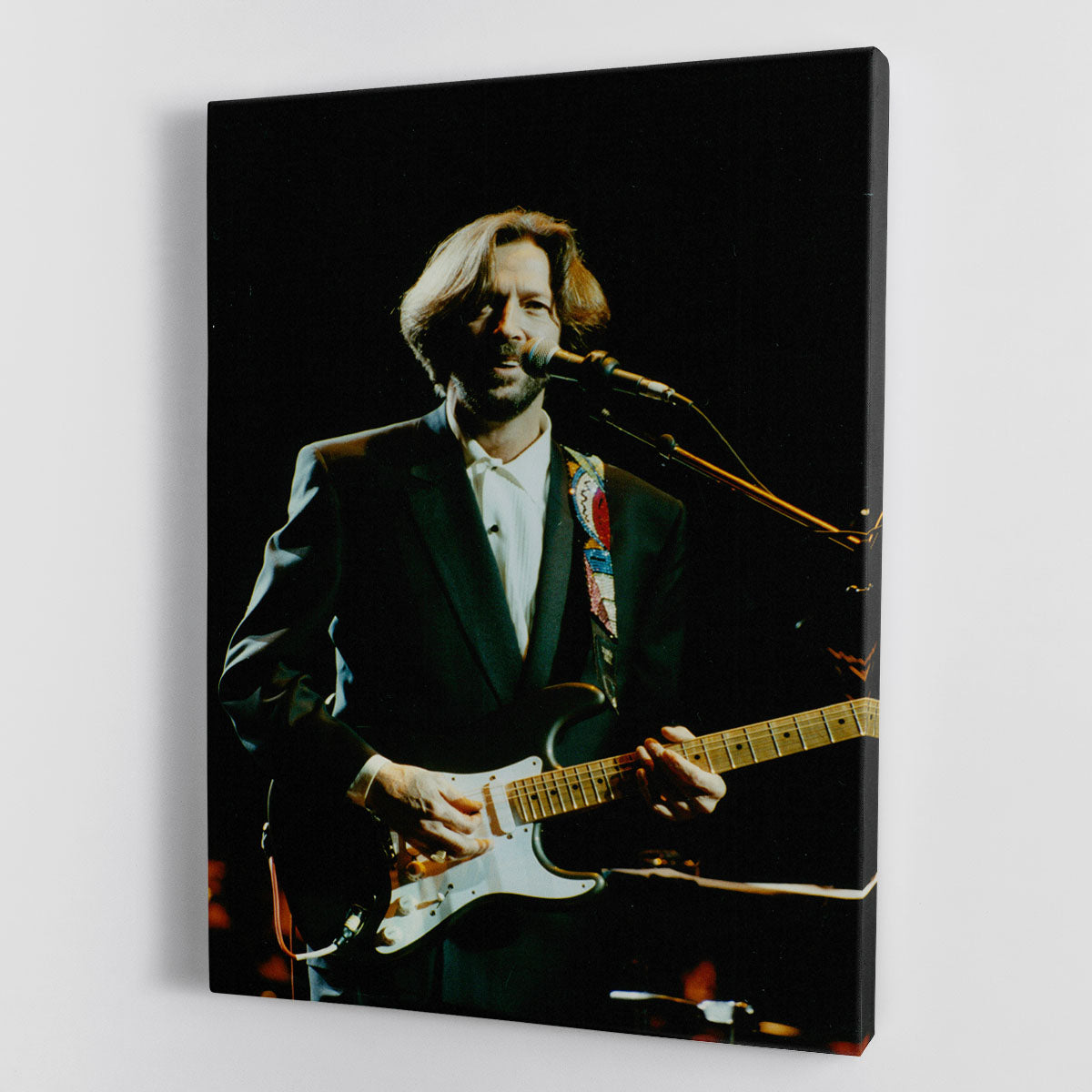 Eric Clapton performing on stage captured in a vibrant canvas print or poster, showcasing his iconic guitar skills and stage presence.