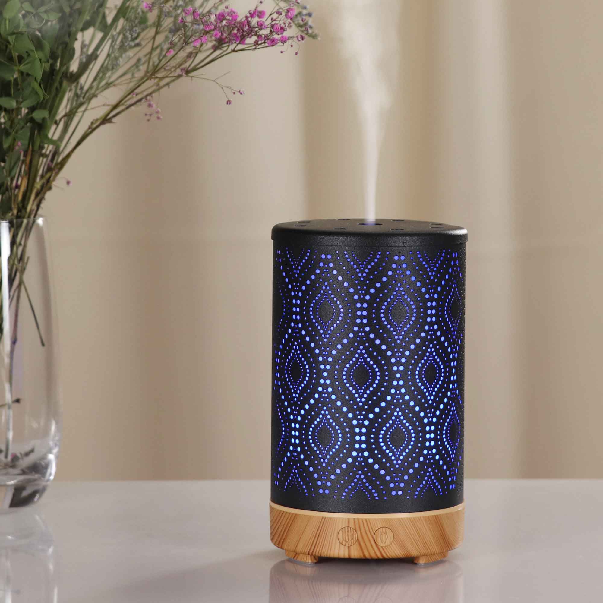 Essential Oil Aroma and Remote Diffuser in black metal with wood grain base, showcasing a modern design and LED lights.