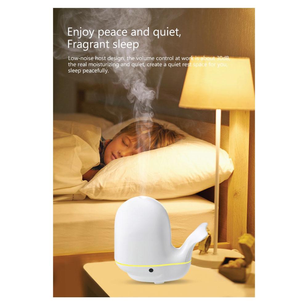 A colorful whale-shaped ultrasonic aroma diffuser with LED lights, designed for children's rooms, showcasing its mist output.