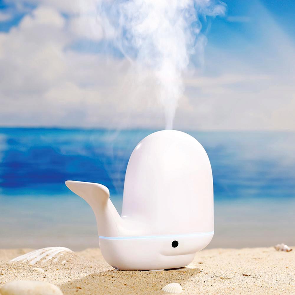 A colorful whale-shaped ultrasonic aroma diffuser with LED lights, designed for children's rooms, showcasing its mist output.