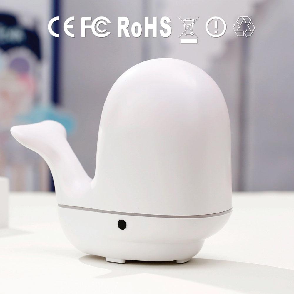 A colorful whale-shaped ultrasonic aroma diffuser with LED lights, designed for children's rooms, showcasing its mist output.
