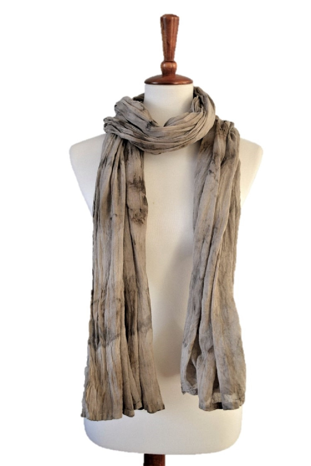 A beautifully woven lightweight cotton scarf, hand-dyed with natural colors like avocado and turmeric, showcasing a chic design.