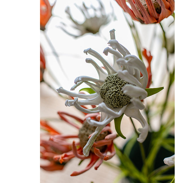 A 39-inch tall faux silk sunflower stem with vibrant orange red and white blooms, showcasing realistic petals and a green stem.