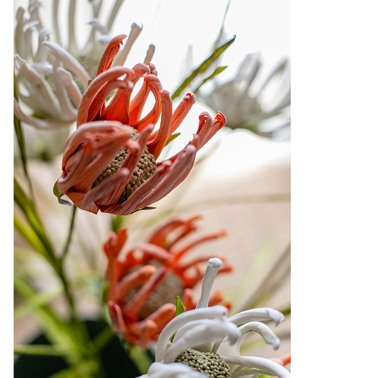 A 39-inch tall faux silk sunflower stem with vibrant orange red and white blooms, showcasing realistic petals and a green stem.