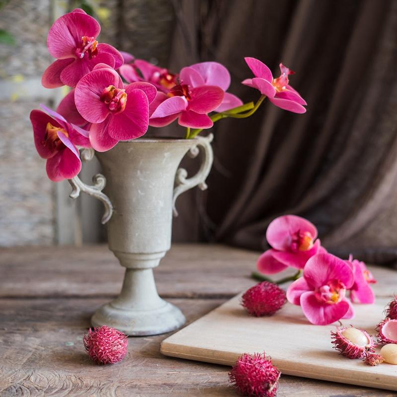 A vibrant Faux Silk Real Touch Orchid in red and purple, showcasing three lifelike flowers on a short stem, perfect for home decor.