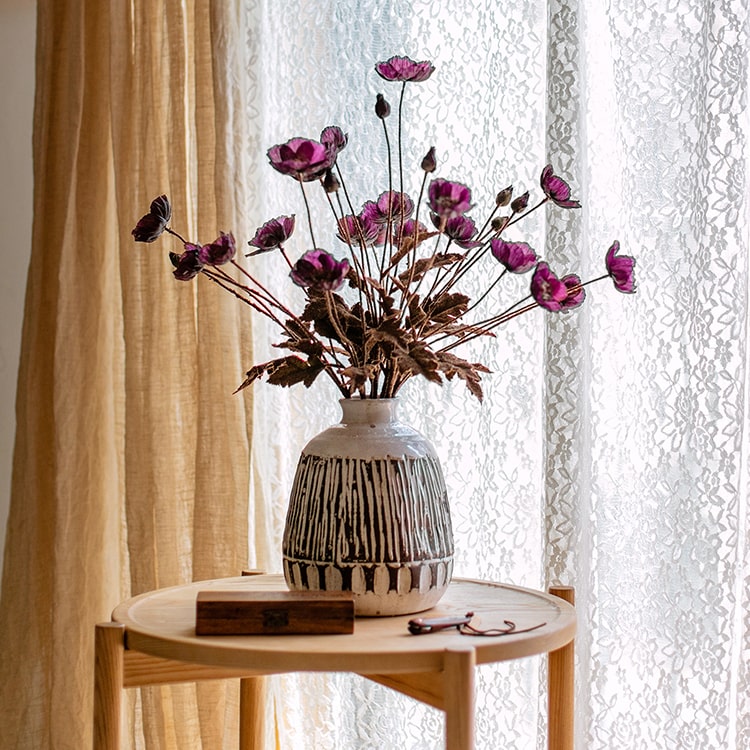 A 23-inch tall faux silk rustic poppy flower stem in purple with three blooms and one bud, featuring green leaves.