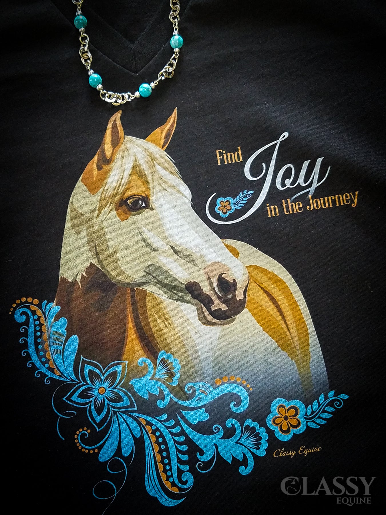 Find Joy in the Journey V-Neck Tee featuring a Paint horse design with ornamental details, available in multiple colors.