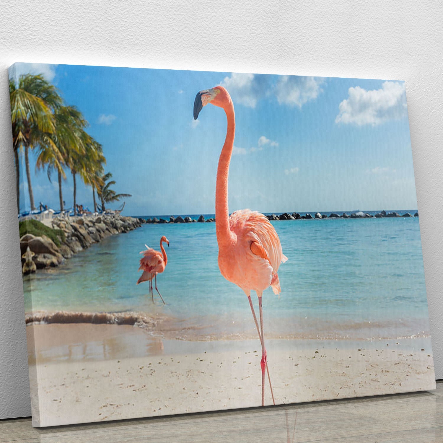A vibrant canvas print featuring flamingos on the sandy shores of Aruba, showcasing tropical beauty and elegance.