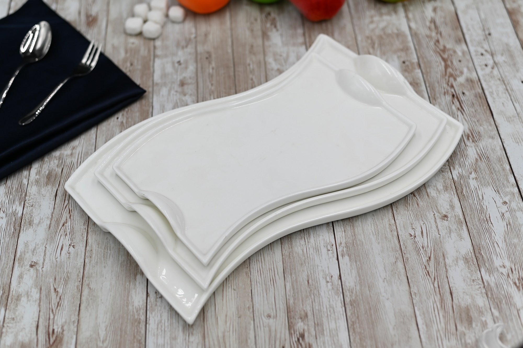 Flat white porcelain serving dish with handles, 10 inches long, featuring a wavy rolled rim, perfect for elegant dining.