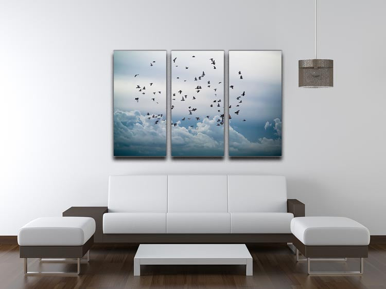 A beautiful 3-panel canvas print depicting a flock of birds flying in a clear blue sky, enhancing any interior decor.
