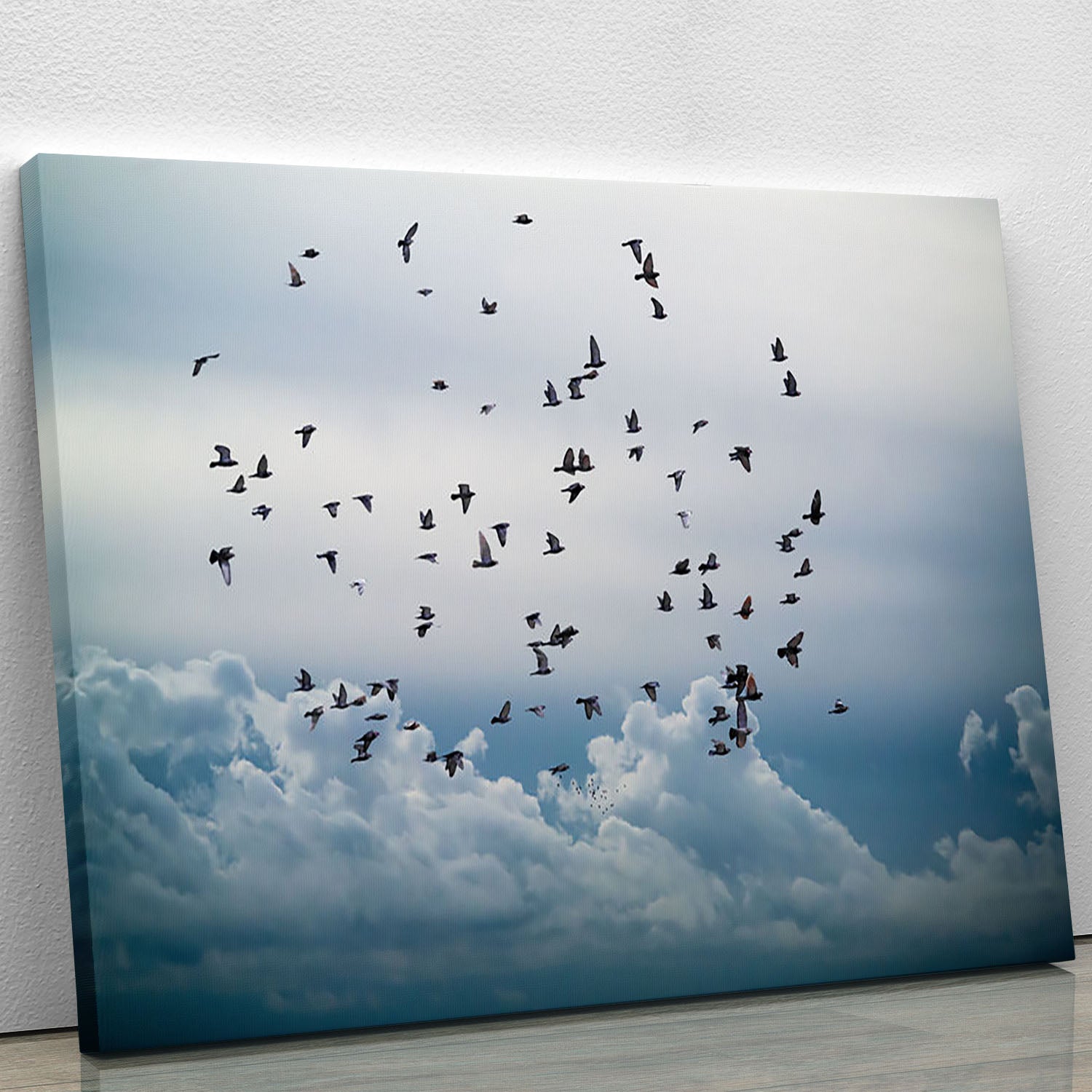 A beautiful canvas print featuring a flock of birds flying gracefully in a clear blue sky, ideal for home decor.