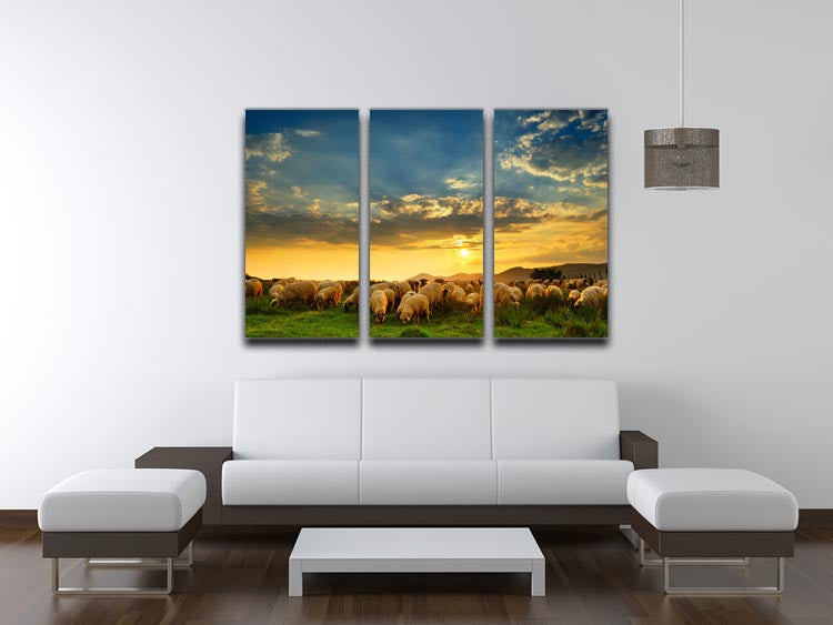 A beautiful 3-panel canvas print depicting a flock of sheep grazing on a hill during sunset, showcasing vibrant colors and serene nature.