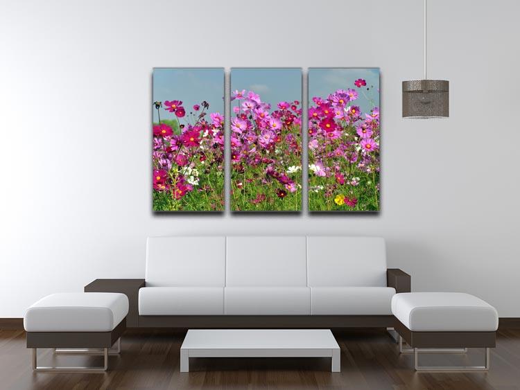 A beautiful 3-panel canvas print featuring a vibrant flower field under a clear blue sky, perfect for home decor.