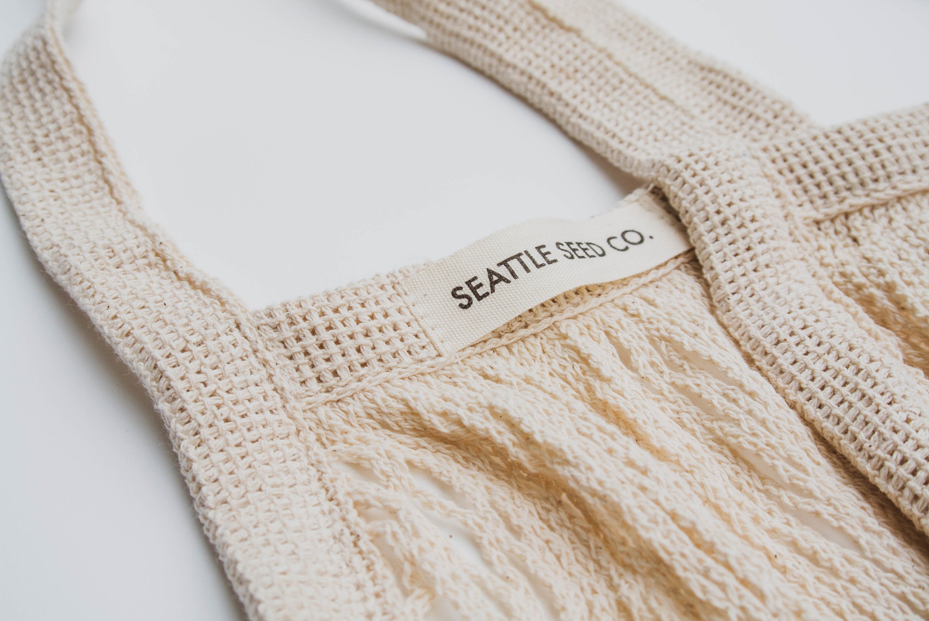 A stylish French Market Tote made of durable cotton string, showcasing its expandable design and natural color, perfect for shopping and travel.