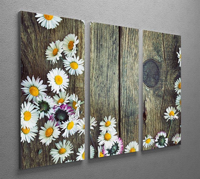 A beautiful 3-panel canvas print featuring fresh daisies on a wooden background, perfect for home decor.
