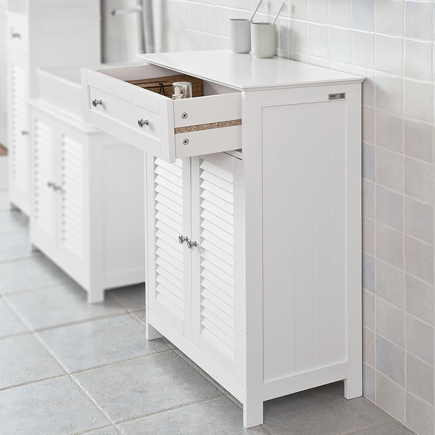 White freestanding storage cabinet with two doors and a drawer, designed for efficient organization in any room.