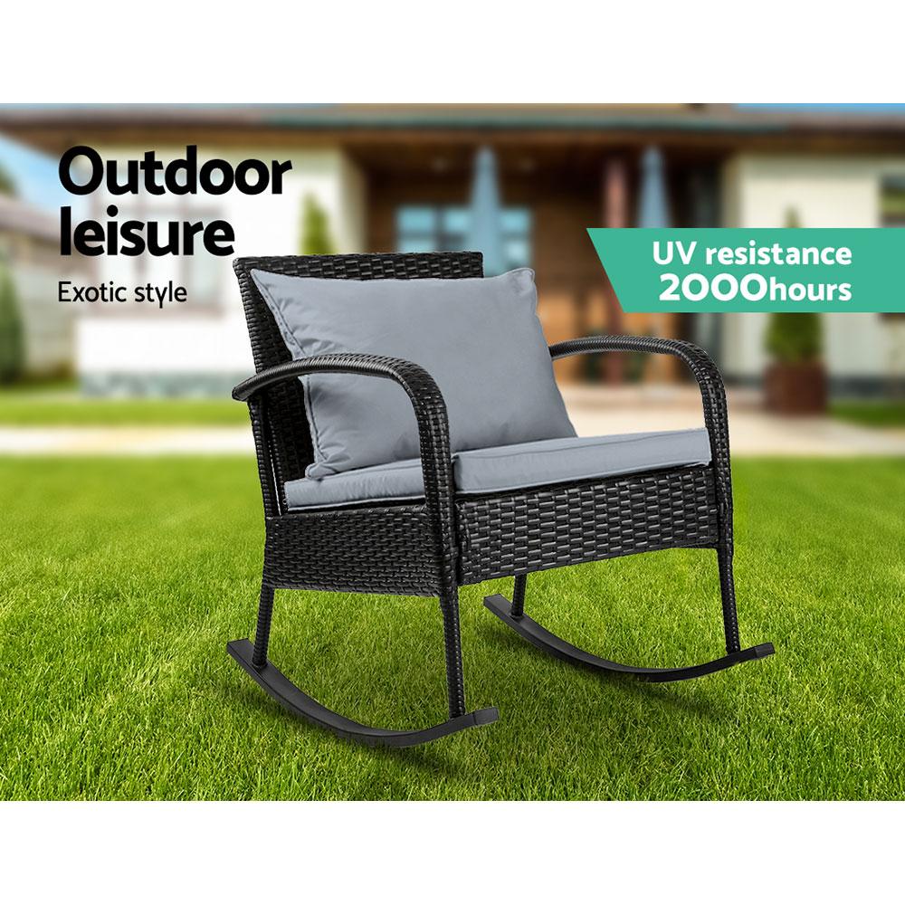 Gardeon Outdoor Rocking Chair in black wicker with grey cushions, set in a garden patio environment, showcasing its elegant design and comfort.