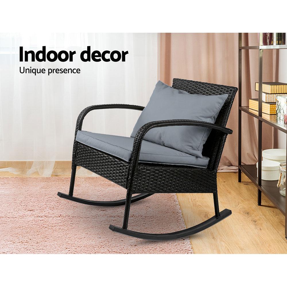 Gardeon Outdoor Rocking Chair in black wicker with grey cushions, set in a garden patio environment, showcasing its elegant design and comfort.