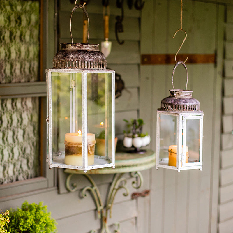 A stylish Glass Metal Lantern Candle Holder featuring a combination of glass and metal in white, gray, and rust colors, perfect for holding candles.