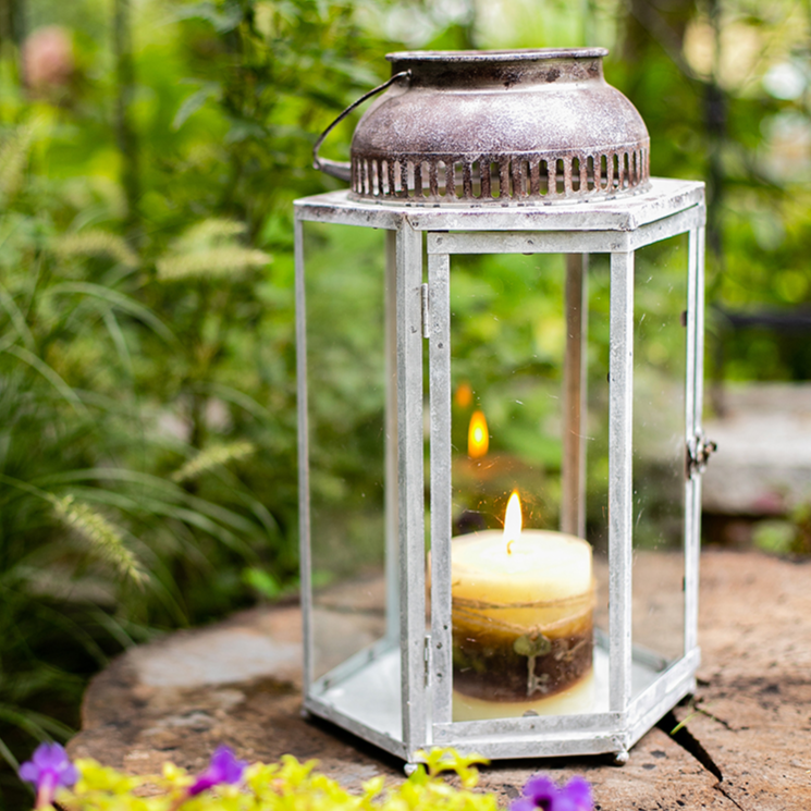 A stylish Glass Metal Lantern Candle Holder featuring a combination of glass and metal in white, gray, and rust colors, perfect for holding candles.