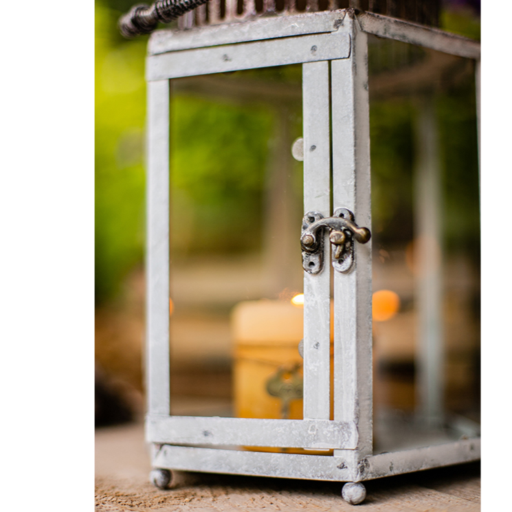A stylish Glass Metal Lantern Candle Holder featuring a combination of glass and metal in white, gray, and rust colors, perfect for holding candles.