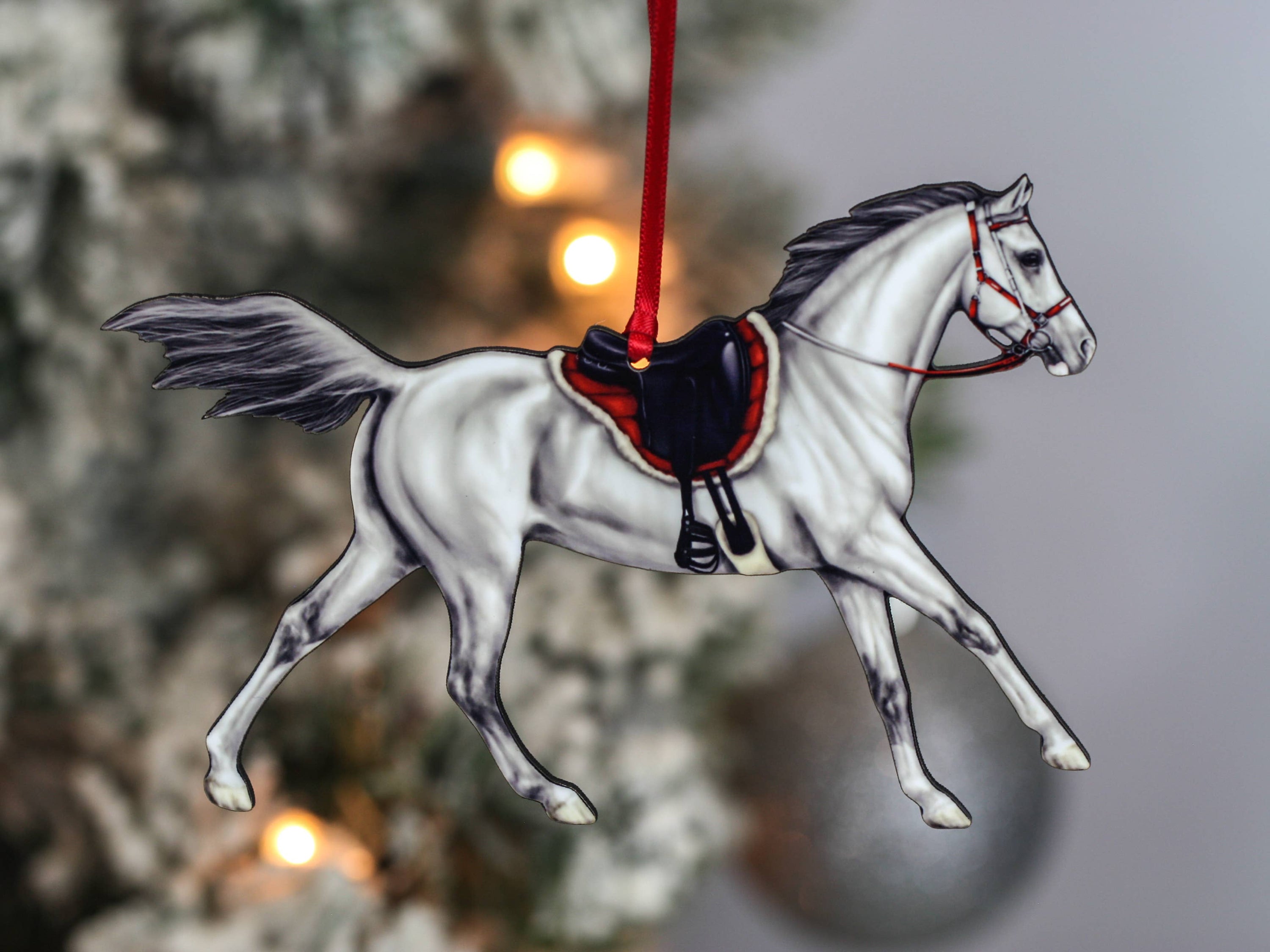 Gray Arabian horse ornament with red and black ribbons, handcrafted from composite wood, perfect for Christmas decor.