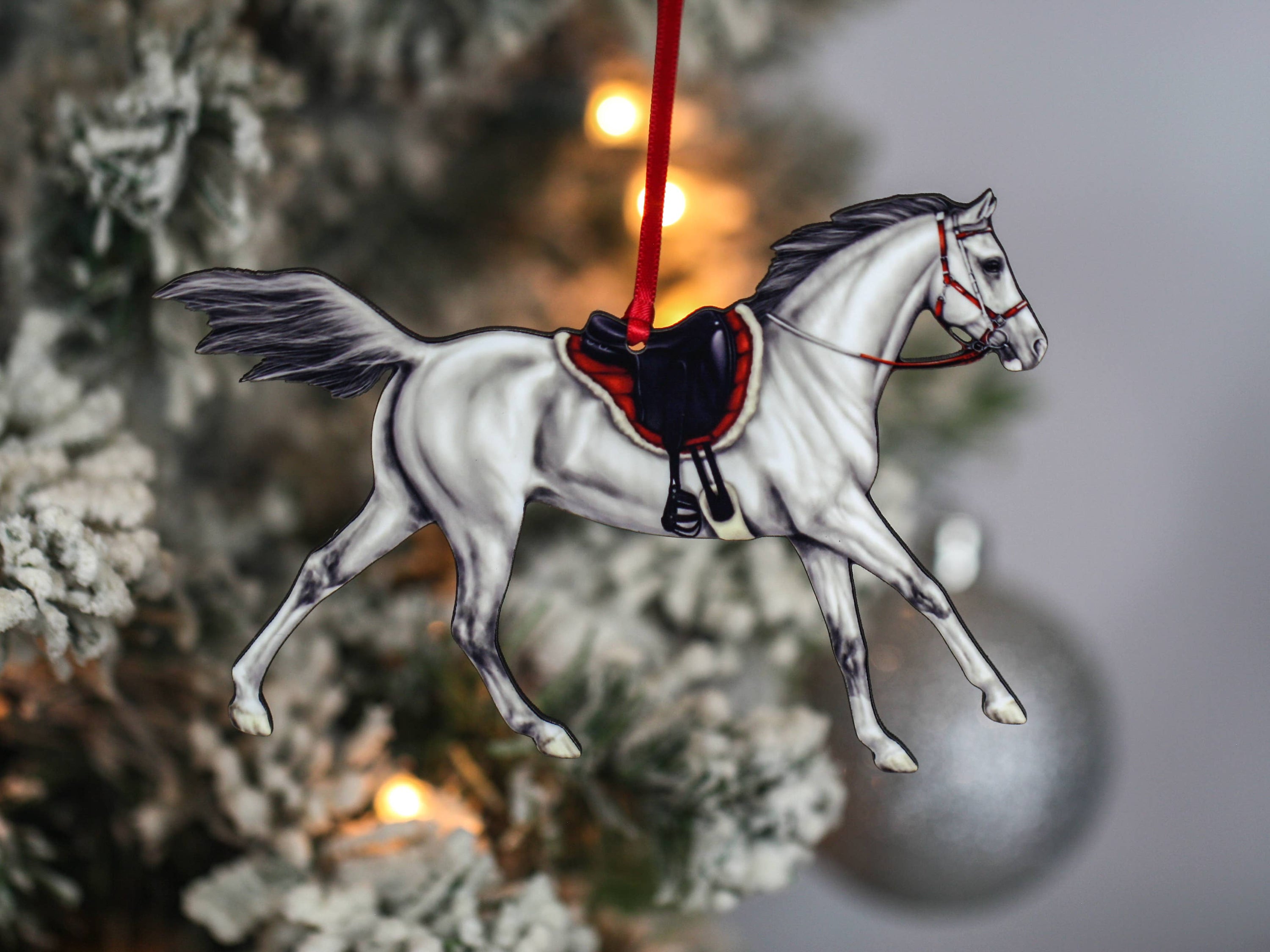 Gray Arabian horse ornament with red and black ribbons, handcrafted from composite wood, perfect for Christmas decor.