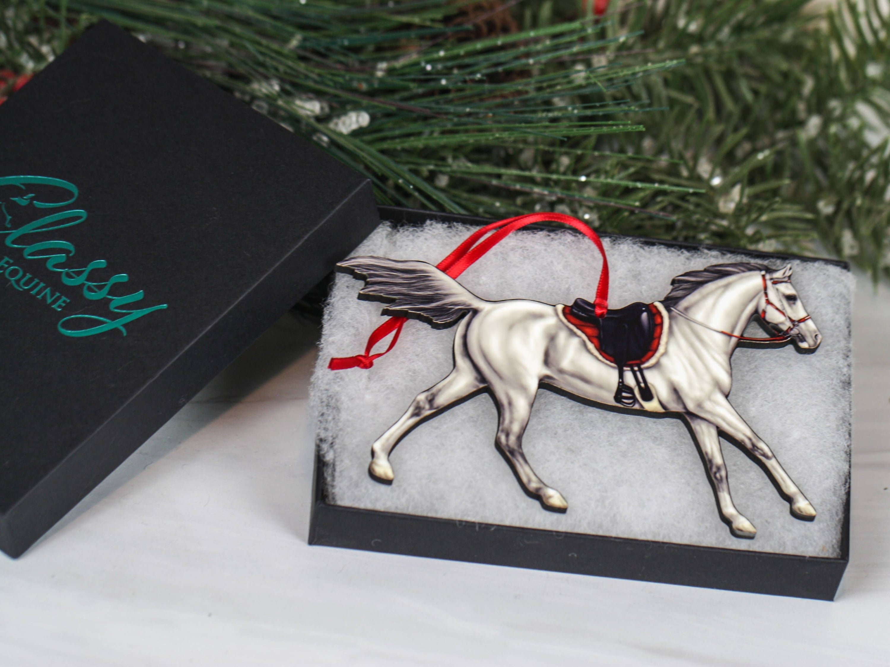 Gray Arabian horse ornament with red and black ribbons, handcrafted from composite wood, perfect for Christmas decor.