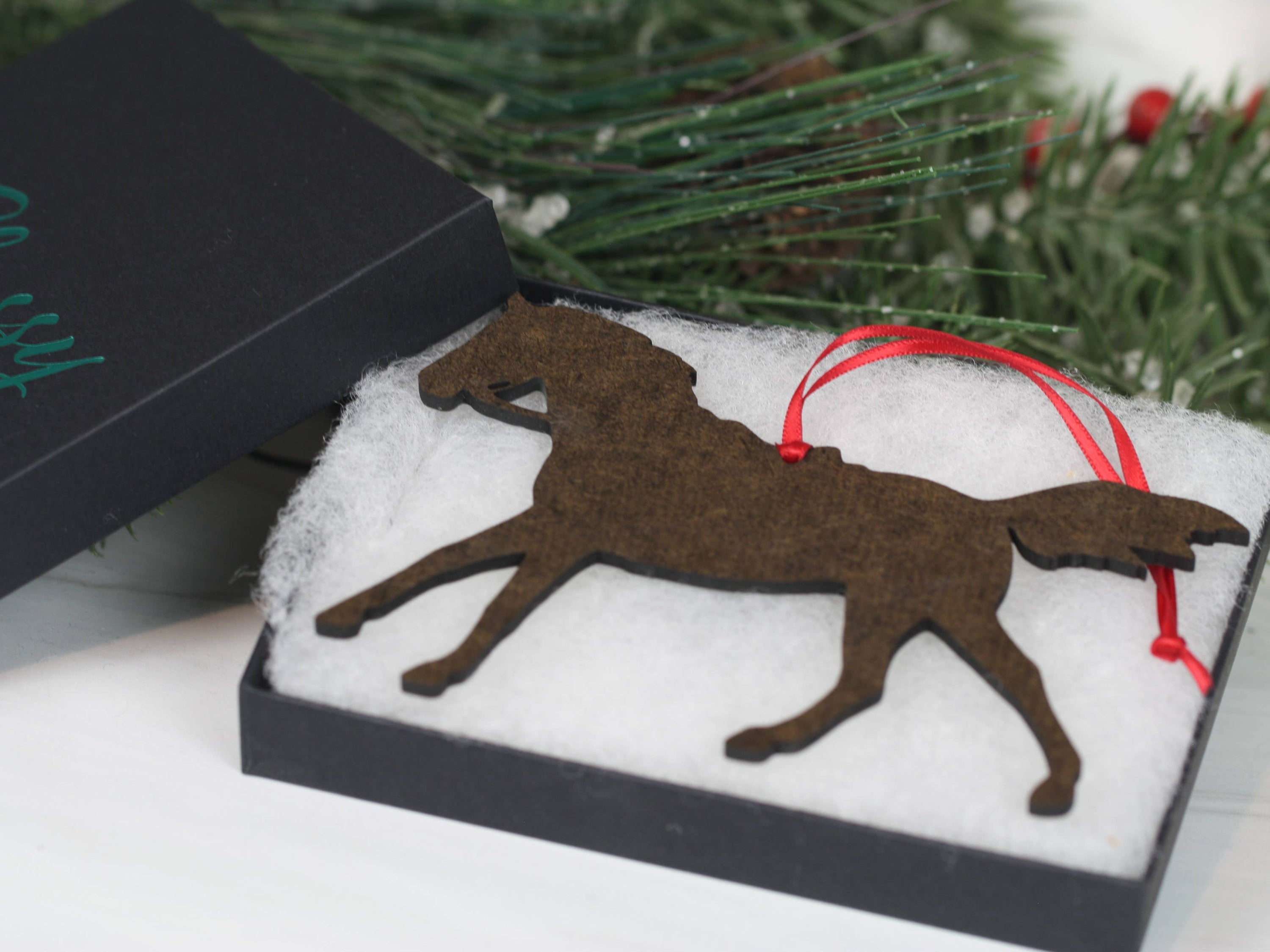 Gray Arabian horse ornament with red and black ribbons, handcrafted from composite wood, perfect for Christmas decor.