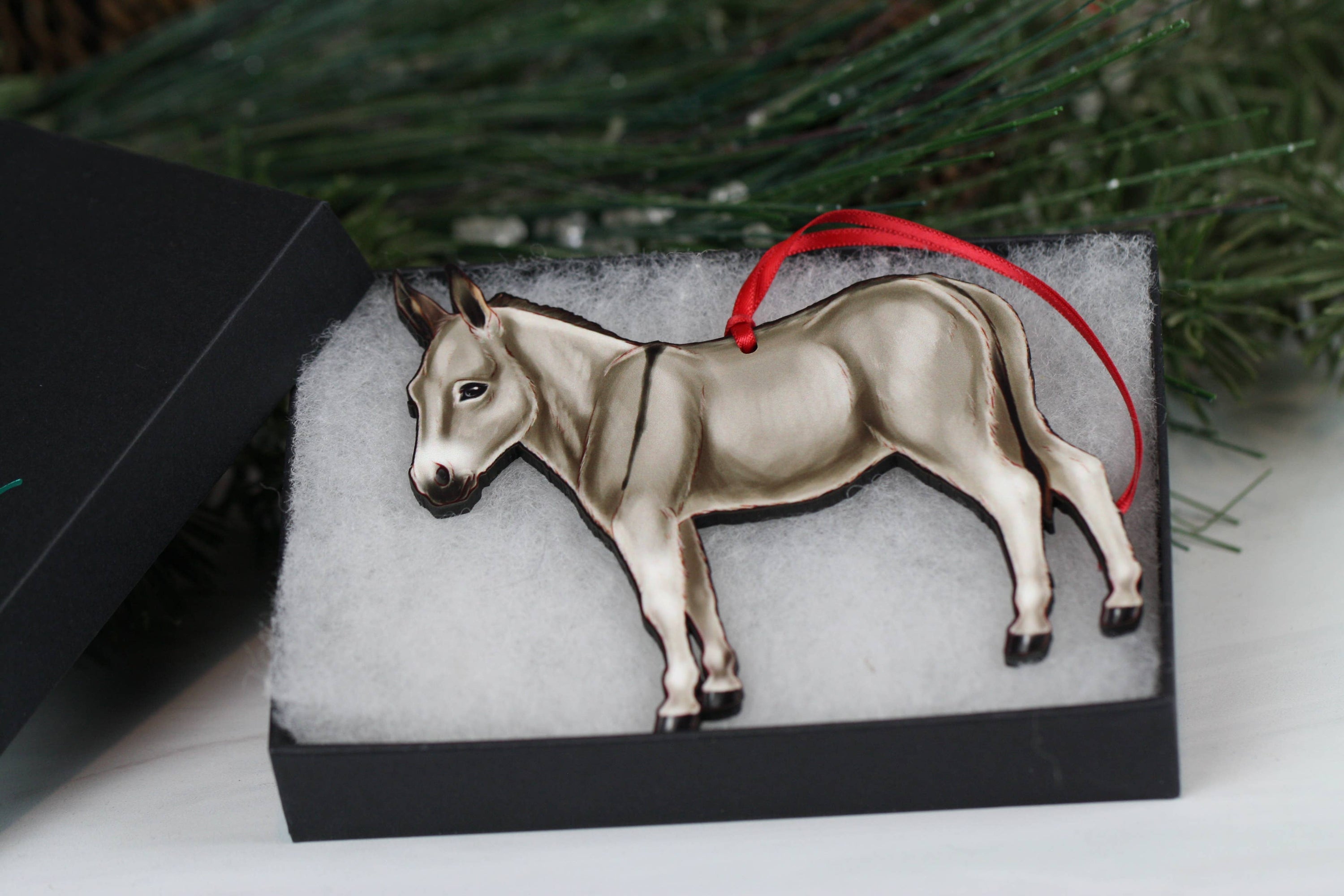 Gray Miniature Donkey Christmas ornament with red and black ribbons, handmade from composite wood, perfect for holiday decor.