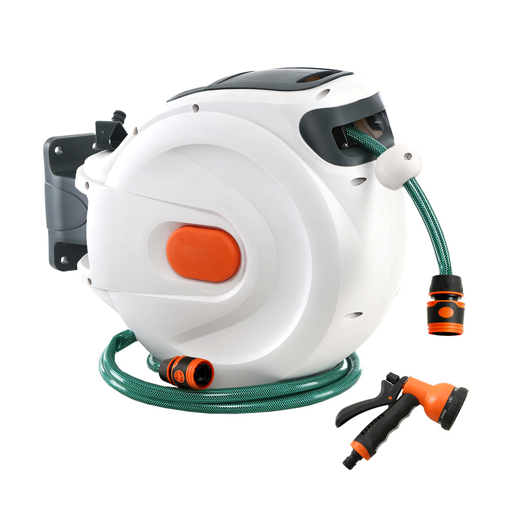 Greenfingers Retractable Hose Reel with 20m hose and adjustable spray gun, mounted on a wall in a garden setting.