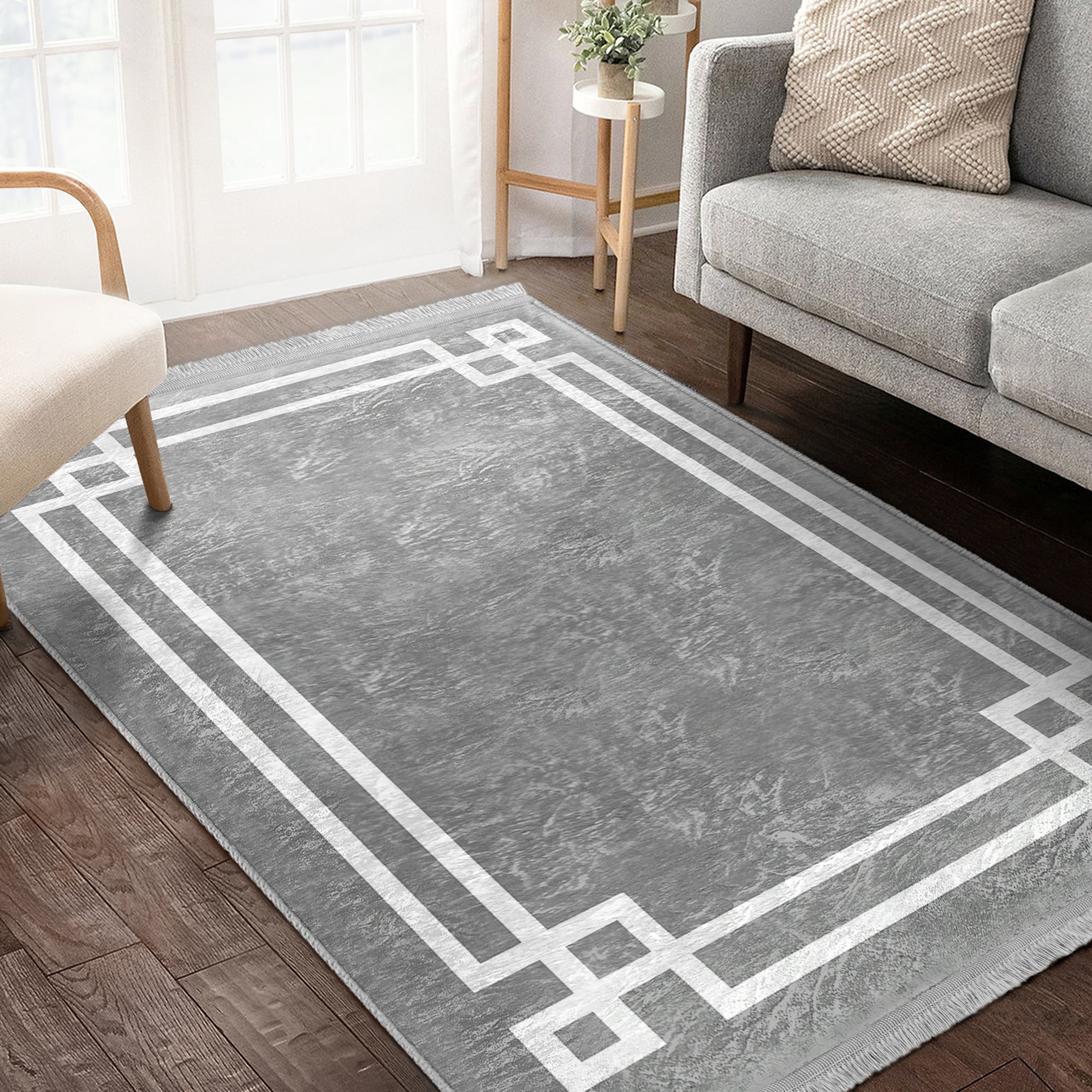 Grey modern area rug with intricate patterns and fringes, showcasing a soft texture suitable for home decoration.