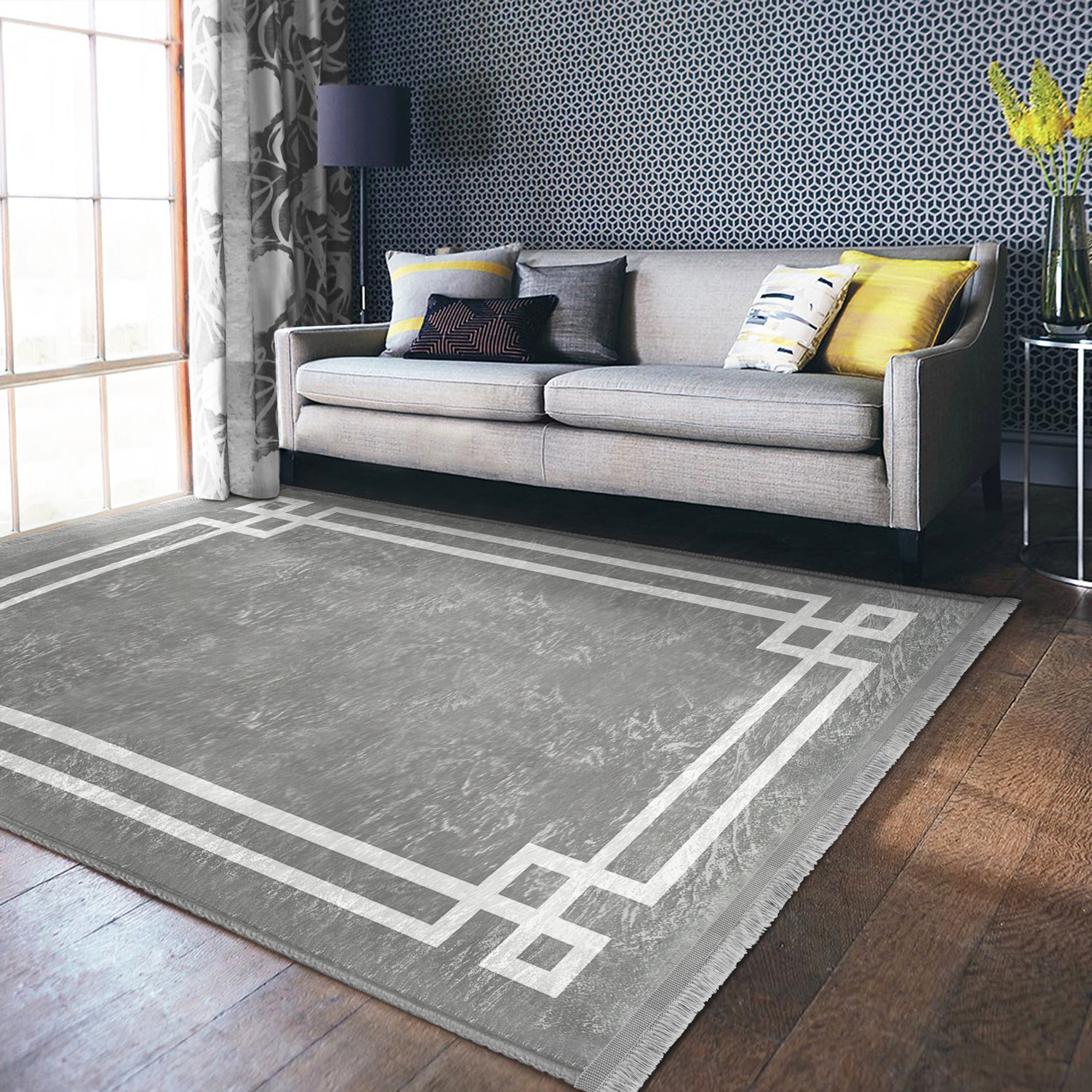 Grey modern area rug with intricate patterns and fringes, showcasing a soft texture suitable for home decoration.