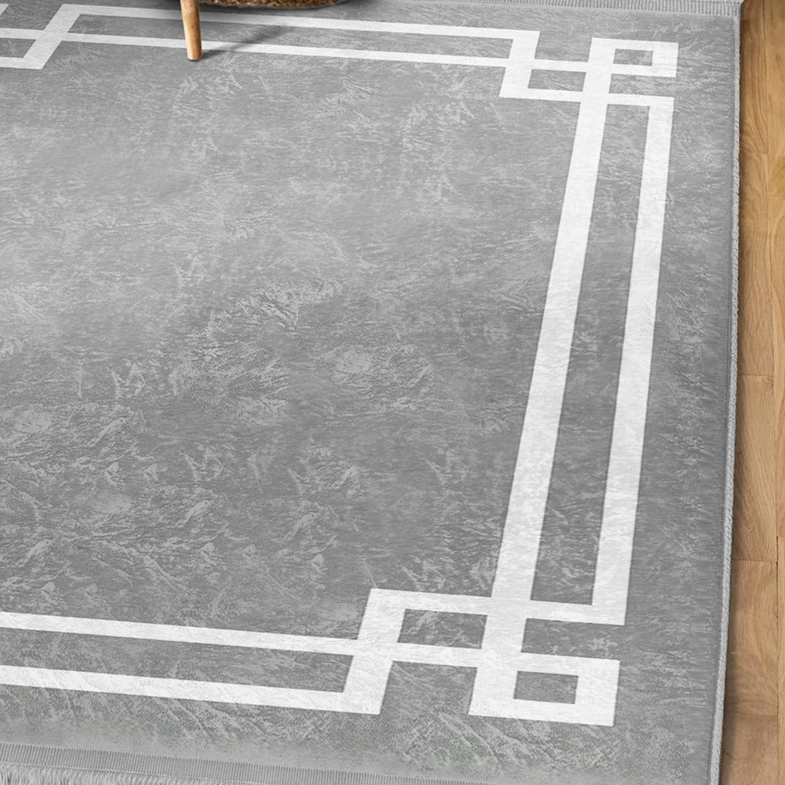 Grey modern area rug with intricate patterns and fringes, showcasing a soft texture suitable for home decoration.