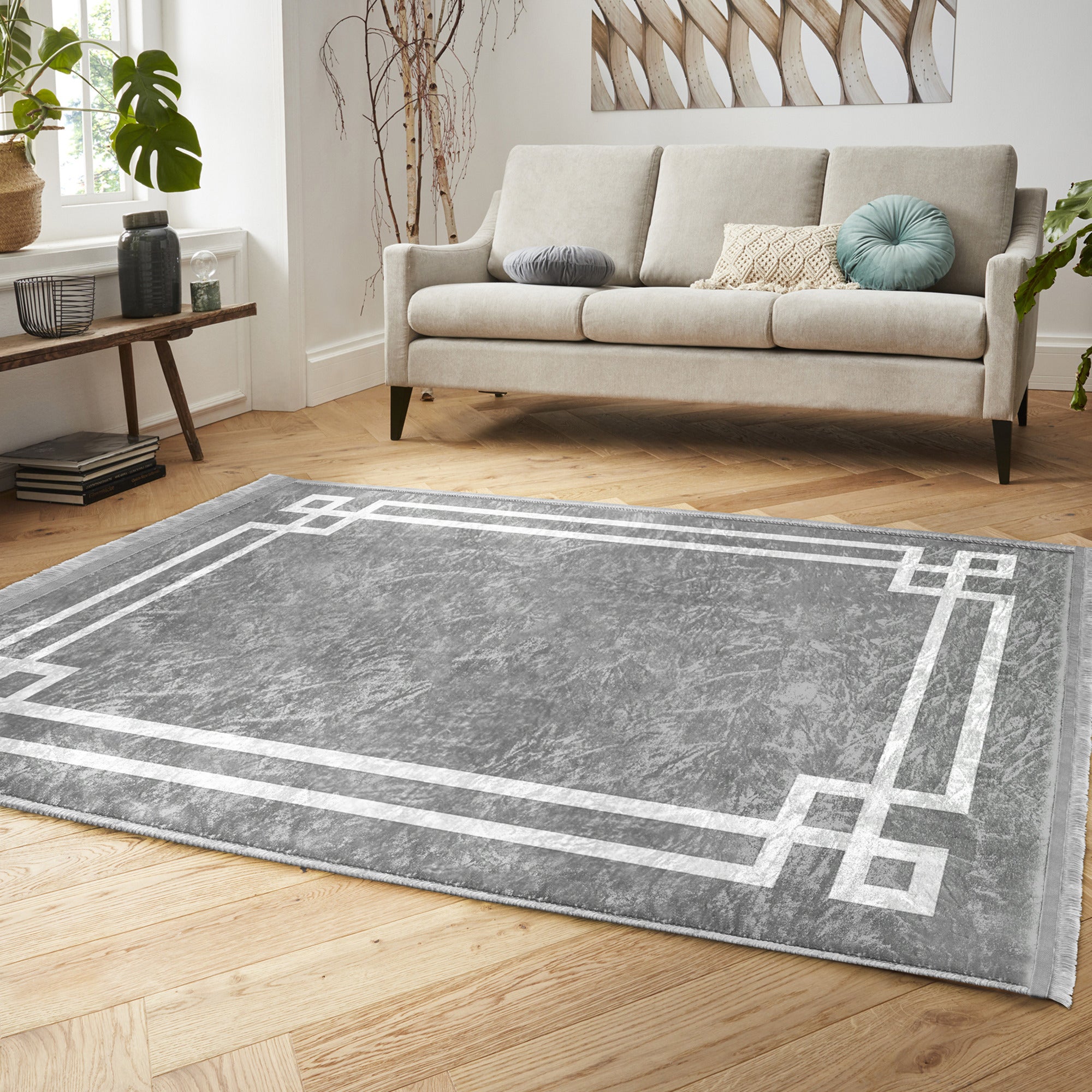 Grey modern area rug with intricate patterns and fringes, showcasing a soft texture suitable for home decoration.