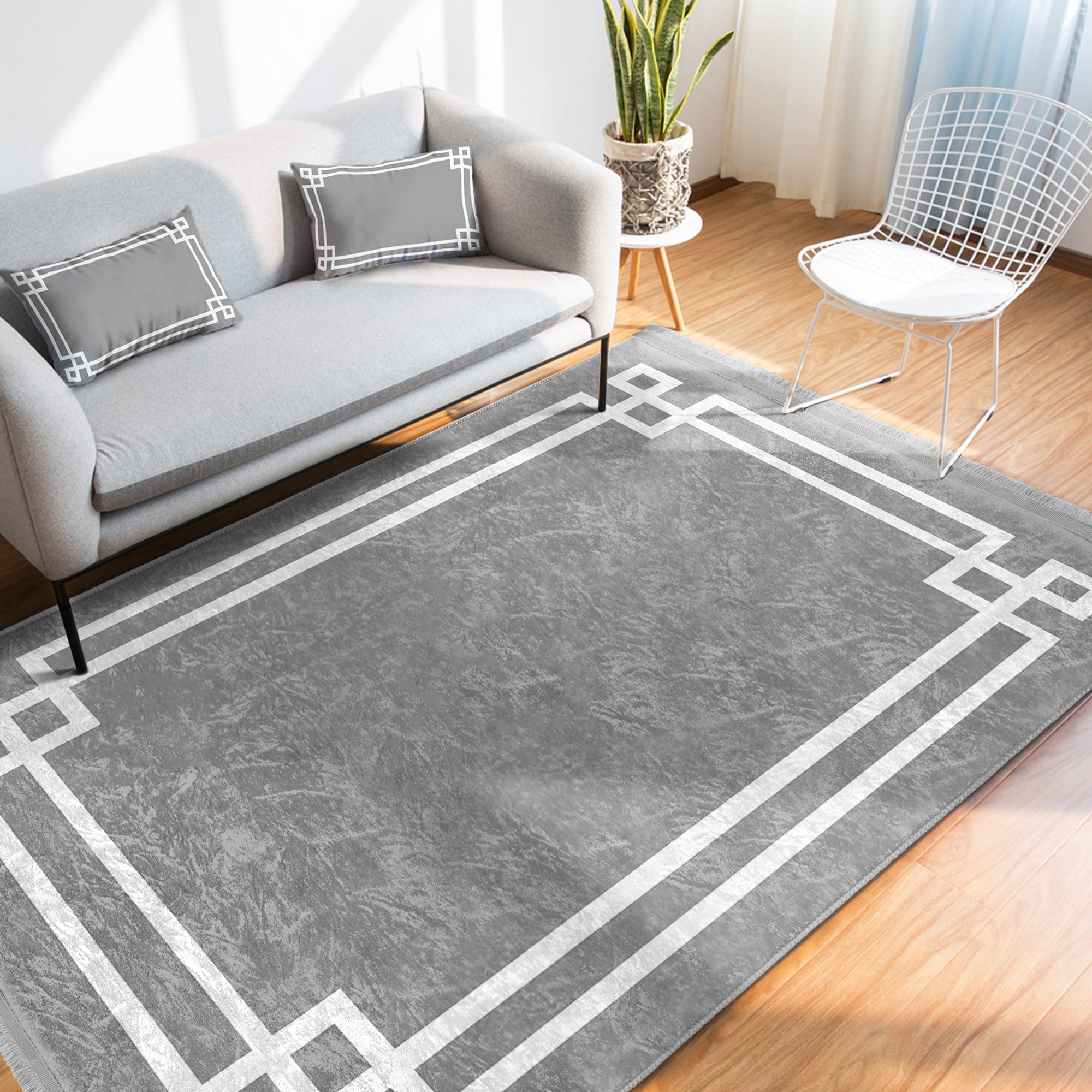 Grey modern area rug with intricate patterns and fringes, showcasing a soft texture suitable for home decoration.