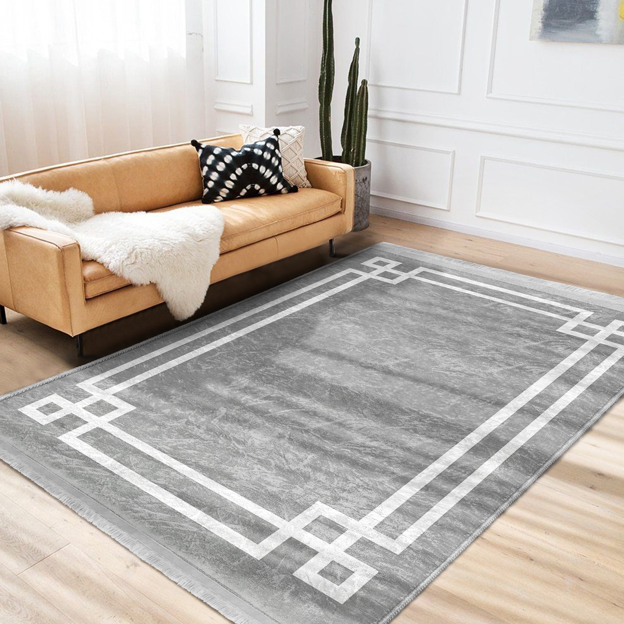 Grey modern area rug with intricate patterns and fringes, showcasing a soft texture suitable for home decoration.