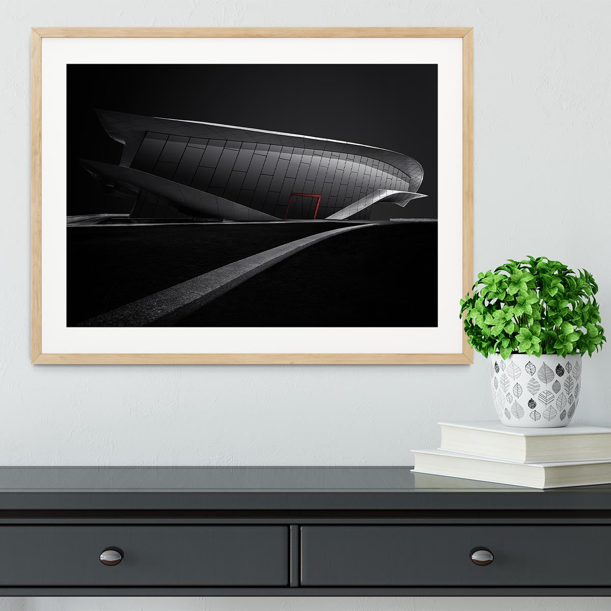 Framed print of greyscale architecture with a touch of red, showcasing a modern design in a stylish frame.