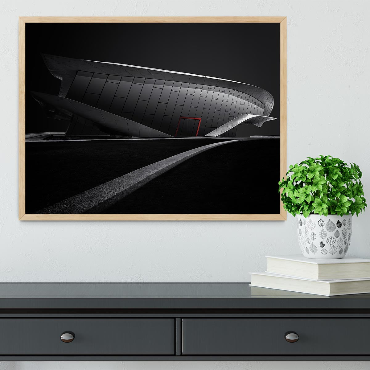 Framed print of greyscale architecture with a touch of red, showcasing a modern design in a stylish frame.