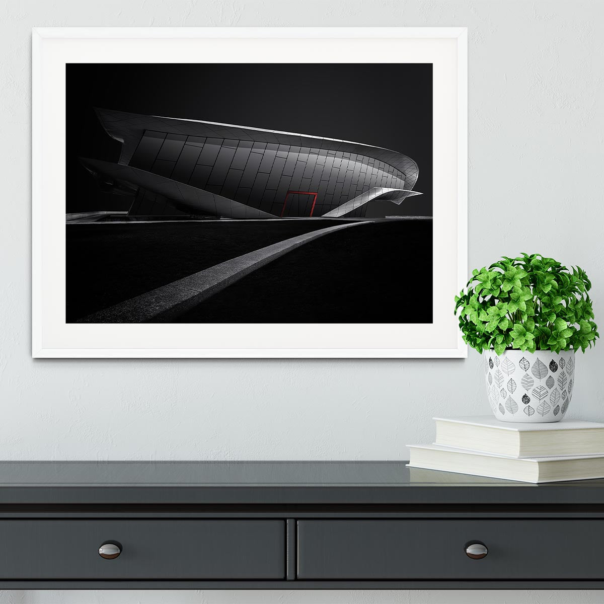 Framed print of greyscale architecture with a touch of red, showcasing a modern design in a stylish frame.