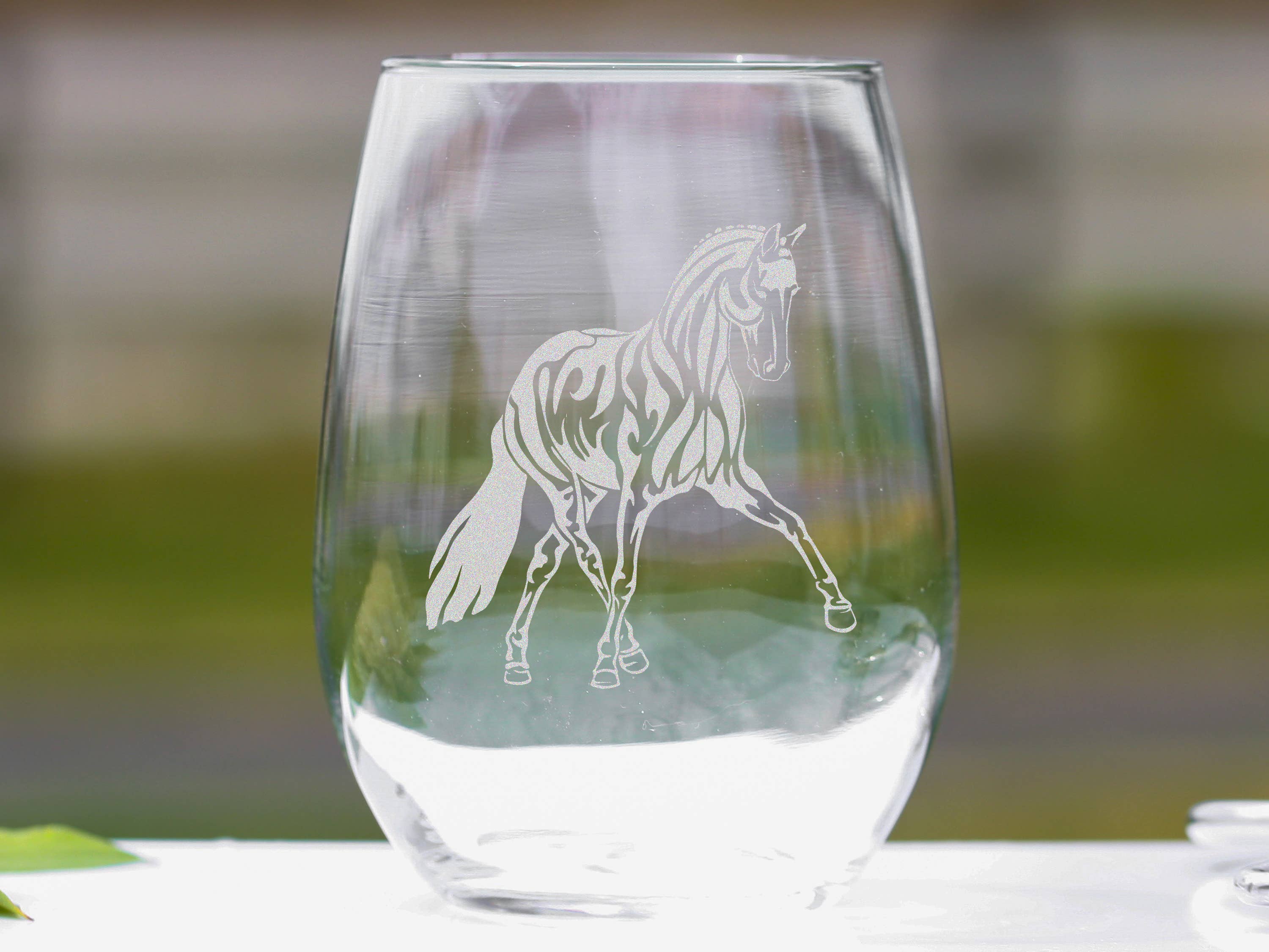 Set of elegant stemless wine glasses featuring a laser engraved dressage horse design, perfect for equestrian enthusiasts.