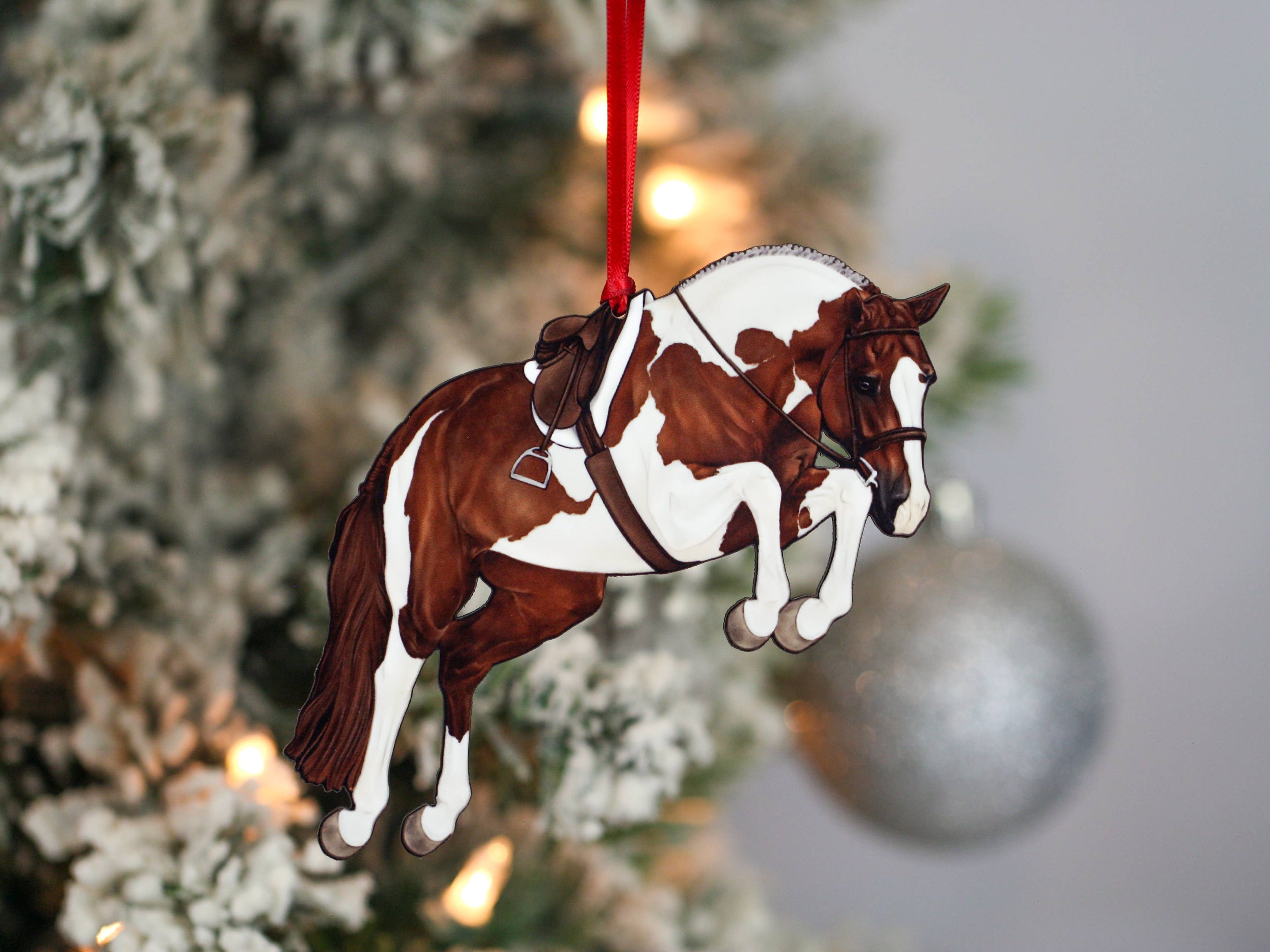 Handcrafted chestnut tobiano hunter jumper horse ornament with red and black ribbons, made from composite wood, perfect for Christmas decoration.