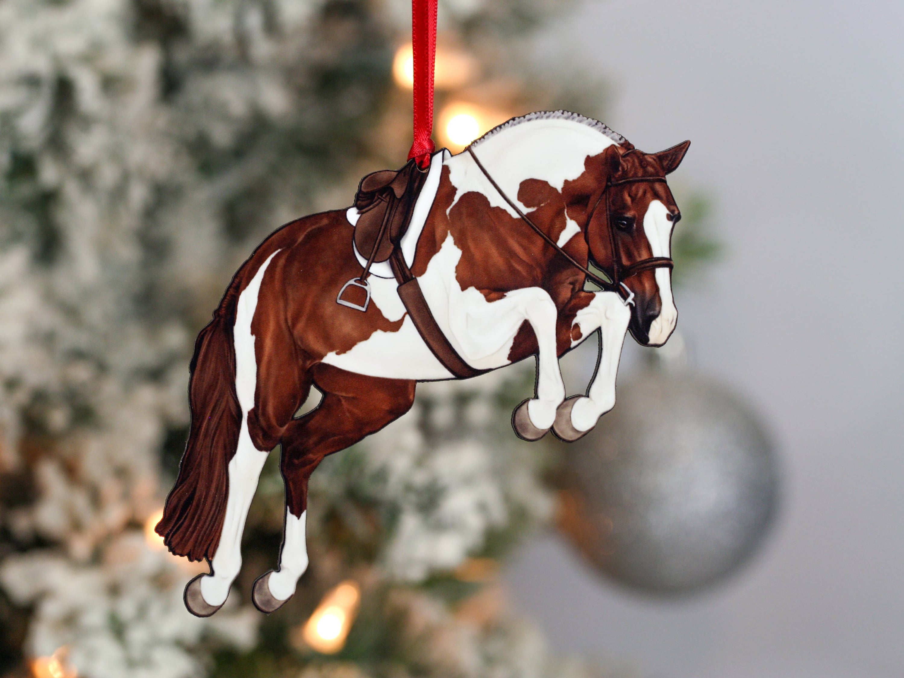 Handcrafted chestnut tobiano hunter jumper horse ornament with red and black ribbons, made from composite wood, perfect for Christmas decoration.
