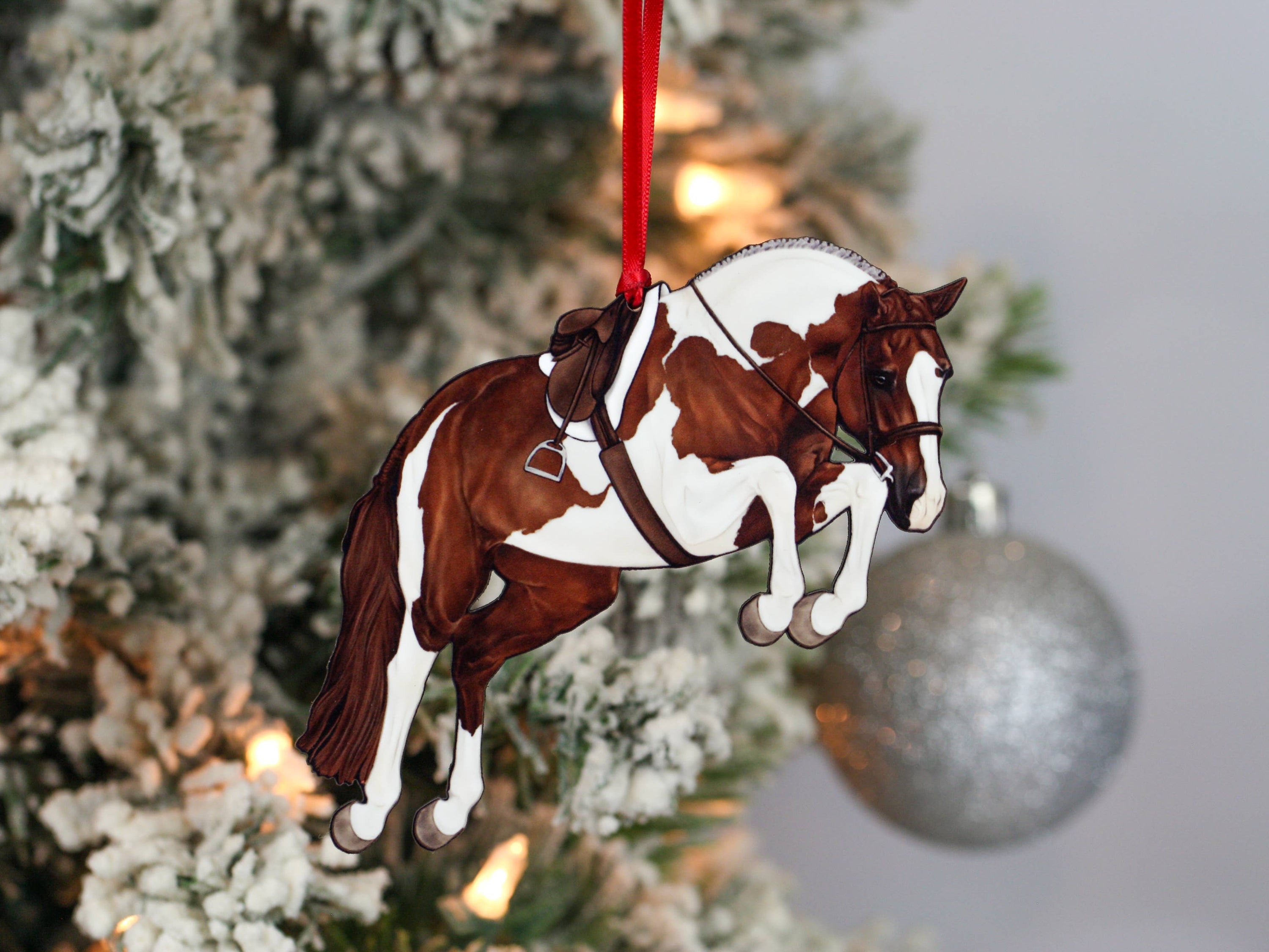 Handcrafted chestnut tobiano hunter jumper horse ornament with red and black ribbons, made from composite wood, perfect for Christmas decoration.