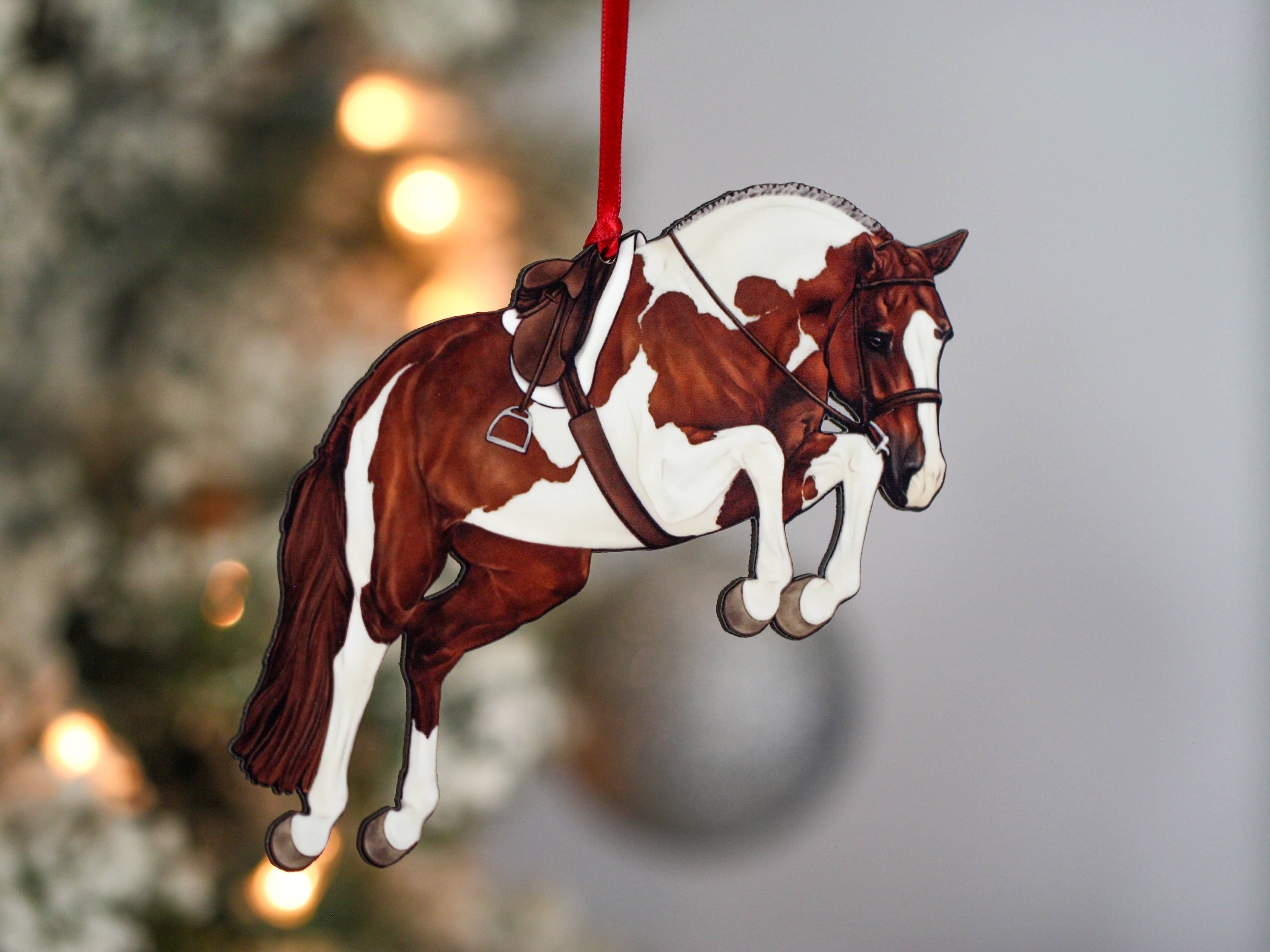 Handcrafted chestnut tobiano hunter jumper horse ornament with red and black ribbons, made from composite wood, perfect for Christmas decoration.