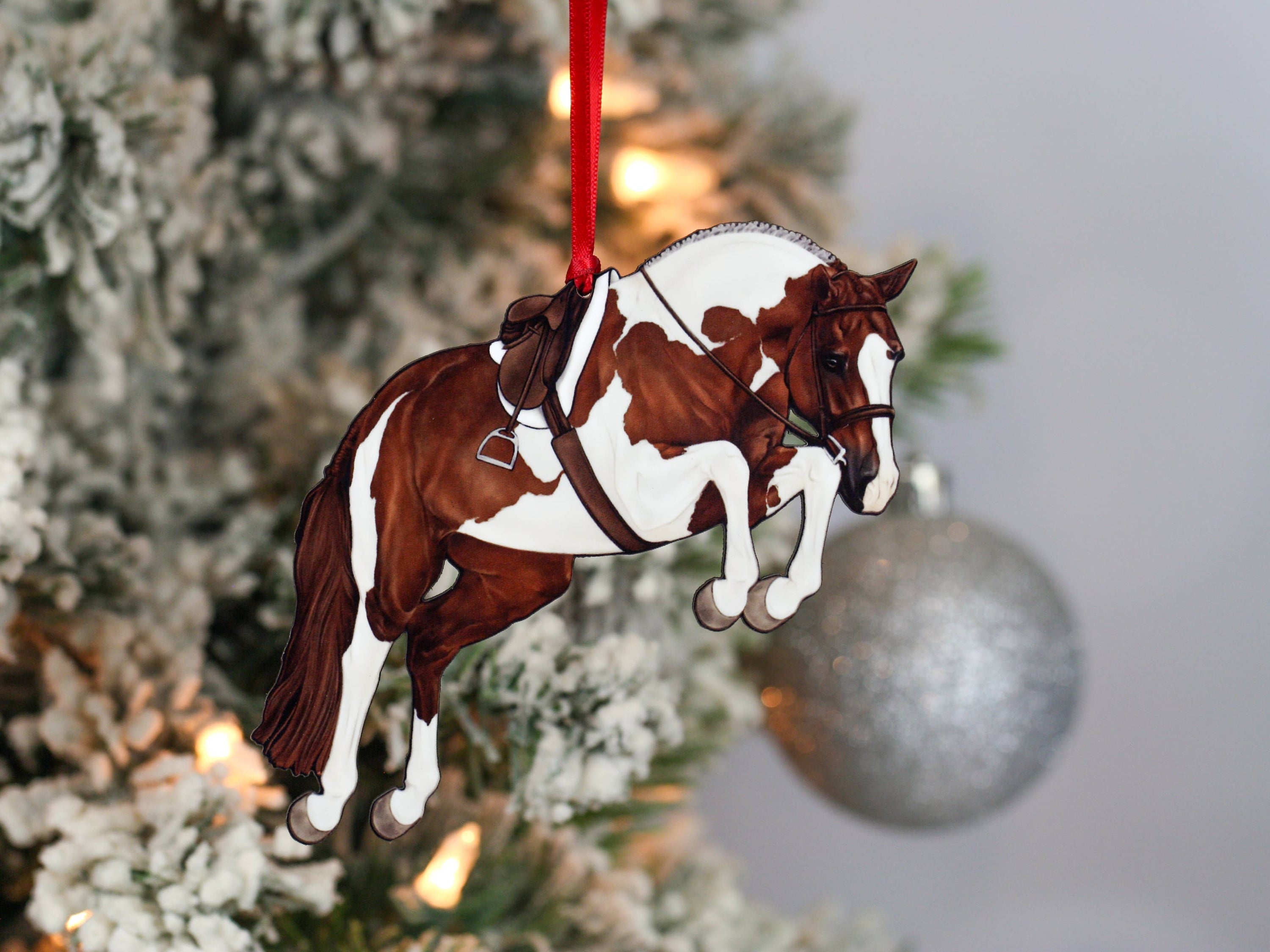 Handcrafted chestnut tobiano hunter jumper horse ornament with red and black ribbons, made from composite wood, perfect for Christmas decoration.