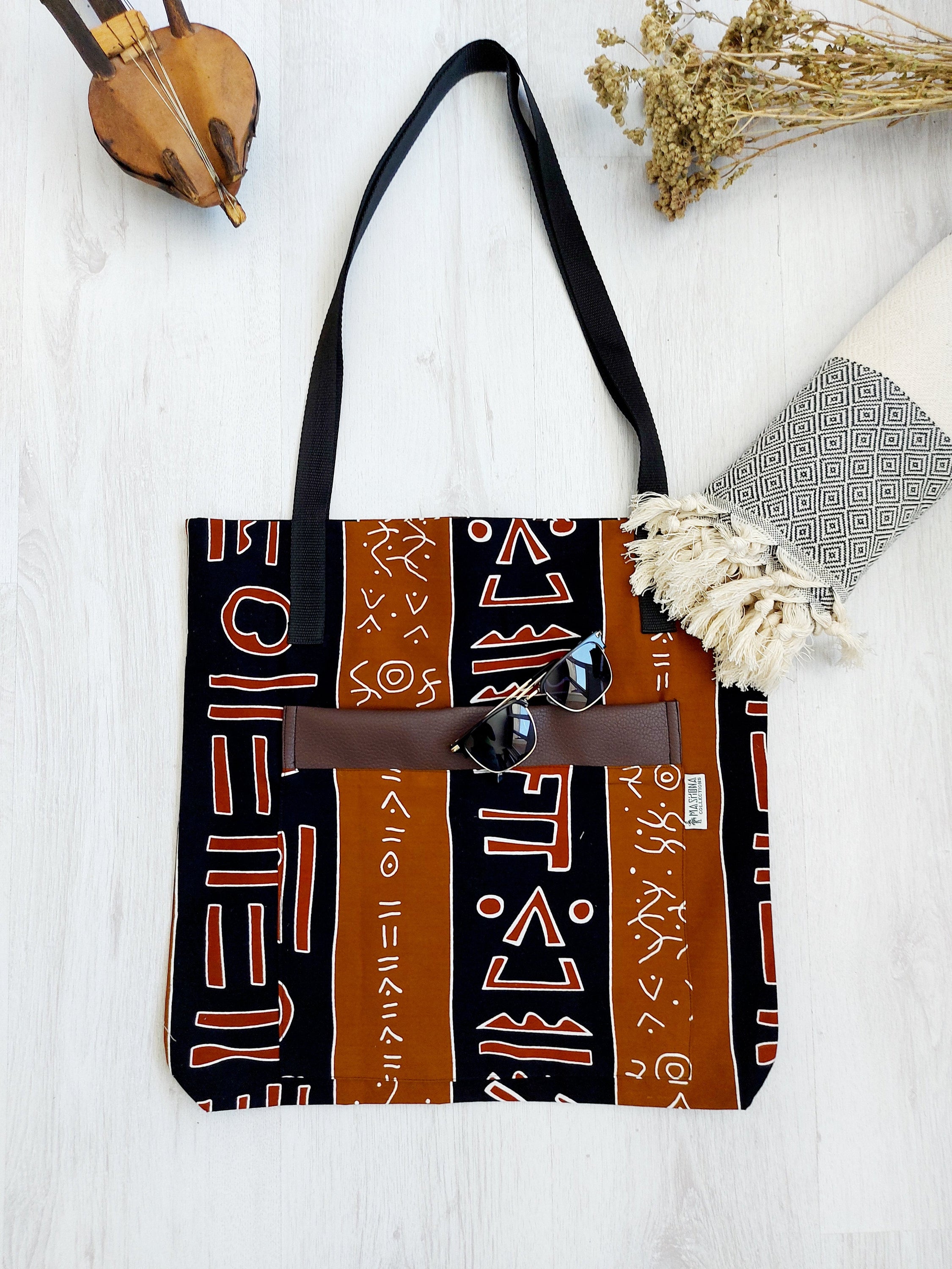 Handmade African Print Tote Bag featuring vibrant patterns, long handles, and durable cotton fabric, perfect for shopping and beach outings.