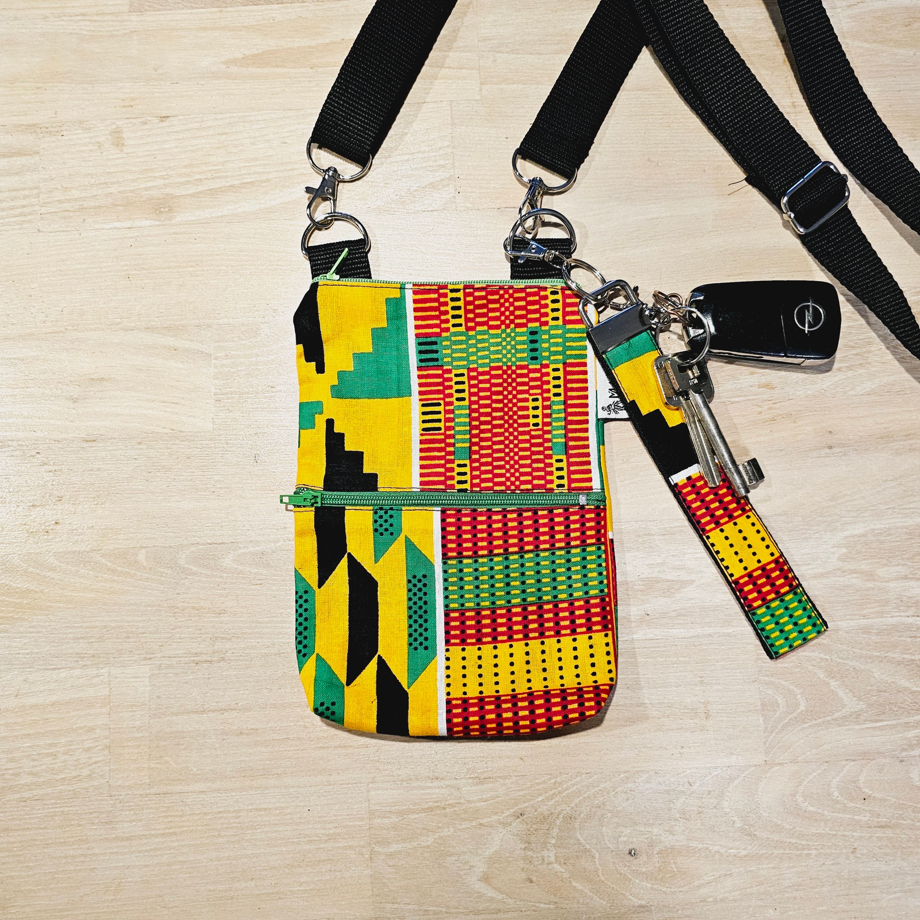 Handmade phone bag featuring vibrant African Ankara print fabric with vegan leather details and detachable wristlet key fob.