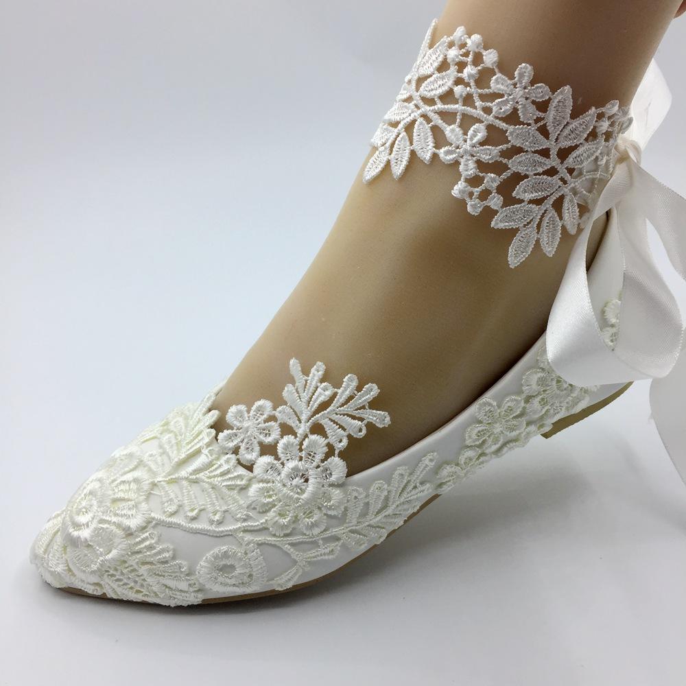 Handmade white lace wedding flat shoes for women, featuring intricate lace detailing and a comfortable flat heel design.